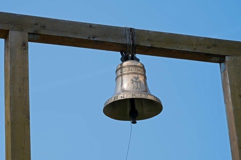 Metal bell on a wooden structure against a clear blue sky, Goshavank monastery, Tavush province,