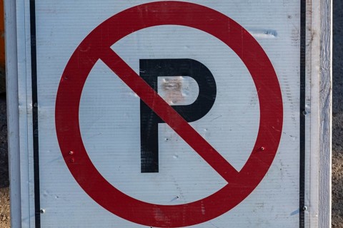 Close-up of posted white, red and black No Parking pictogram notice sign outdoors, Quebec, Canada