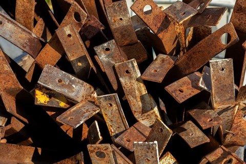 Close-up of pile of old rusted steel support brackets with bored holes, Quebec, Canada
