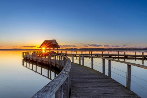 Wooden jetty on Lake Hemmelsdorf / Hemmelsdorfer See at sunrise in spring near Lübeck,