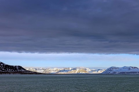 Snow covered mountains and glaciers debouching into Lilliehöökfjorden, fjord branch of Krossfjorden