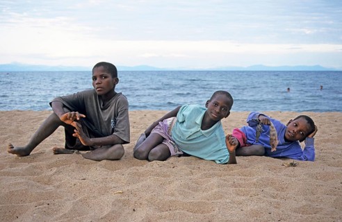 Three local boys posing for the camera on the beach, Chitimba, Lake Malawi, Africa, July 2000,