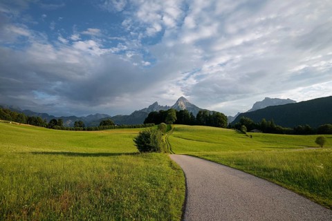 Watzmann at sunset, with meadow and pasture in summer, sunbeams and clouds. Berchtesgaden, Bayern,