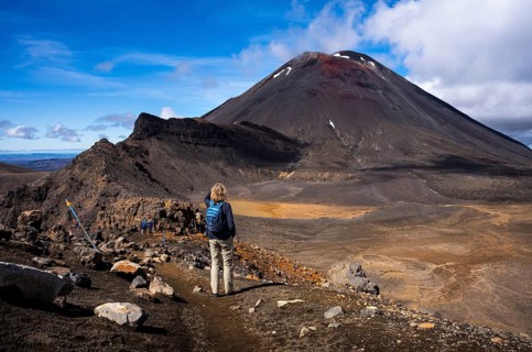A hiker on the Tongariro Alpine Crossing trail. View of Mt Ngauruhoe. Tongariro National Park.