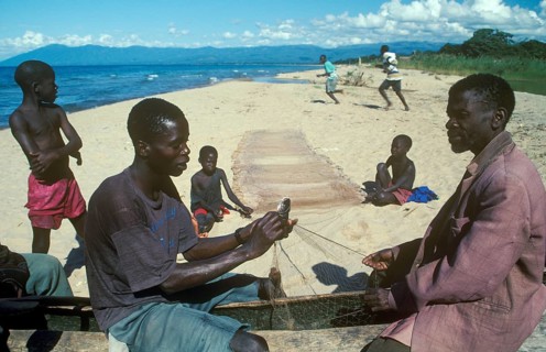 Fishermen at Kande Beach on Lake Malawi repair their nets, Malawi, Africa, July 2000, vintage,