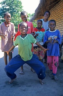 Local children dance happily to music in a village near Kande, Lake Malawi, Malawi, Africa, July