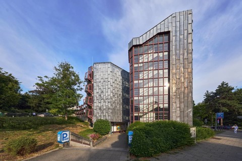 Theatre car park, modern architecture, entrance, access, sidewalk, trees, bushes, lawn, blue sky,