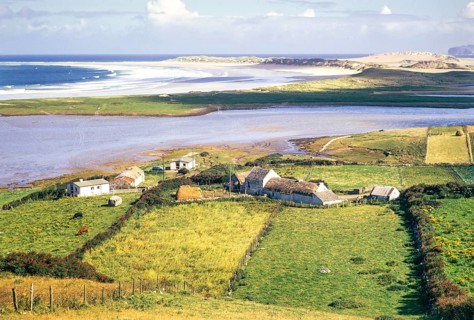 View over thatched farmhouse buildings to Magheraroarty Beach, Meenlaragh, County Donegal, Ireland