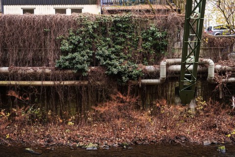 District heating pipeline in front of old industrial buildings on the banks of the Wupper,