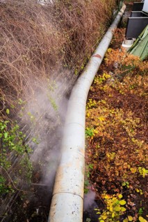 District heating pipeline in front of old industrial buildings on the banks of the Wupper,