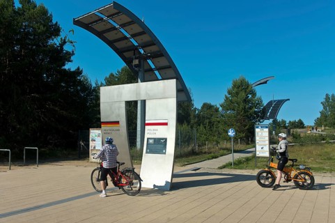 Cyclists at the symbolic gate on the border between Germany and Poland on the Europa Promenade,