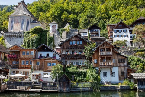 A, Hallstatt, central European village with old wooden houses on the water, surrounded by nature,