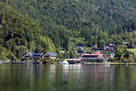 A, Hallstatt, A small lakeside village with boats and green forests in the background, Austria