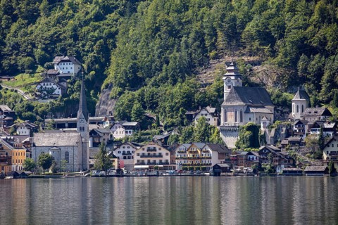 A, Hallstatt, A picturesque lakeside village with church in front of wooded mountains, Austria