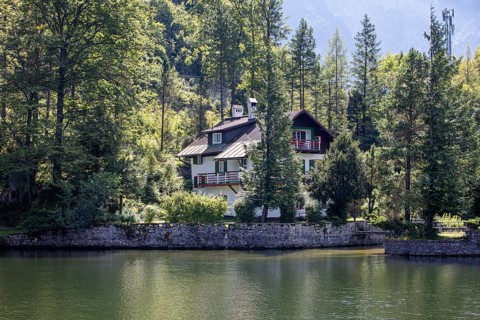 A, Hallstatt, A cozy house tucked away on the edge of a quiet lake surrounded by thick forest,