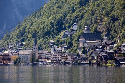 A, Hallstatt, A picturesque mountain village with lakeside churches in front of a steep forest