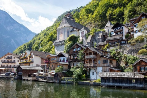 A, Hallstatt, houses on the water in front of green mountains, traditional architecture in