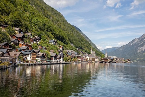 A, Hallstatt, panorama of a picturesque lakeside village with mountains in the background and a