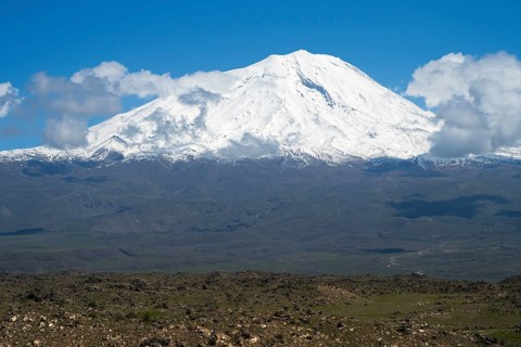 Impressive snow-covered mountain surrounded by clouds in a wide landscape, landscape near