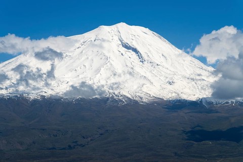 Majestic snow-covered mountain with some clouds under clear blue sky, landscape near Demirtepe,