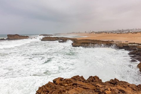 Stormy coastal scene with breaking waves and rocky landscape