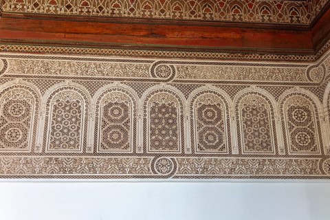 Complex arabesque patterns adorn a wall in a traditional style. Bahia Palace in Marrakech, Morocco