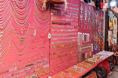 Market stand with colorful jewelry against a red background