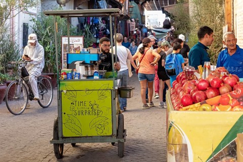 Street stand with fruit and a vendor on a busy street