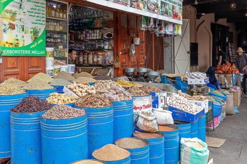 Market stand with a variety of spices and dried herbs in blue barrels