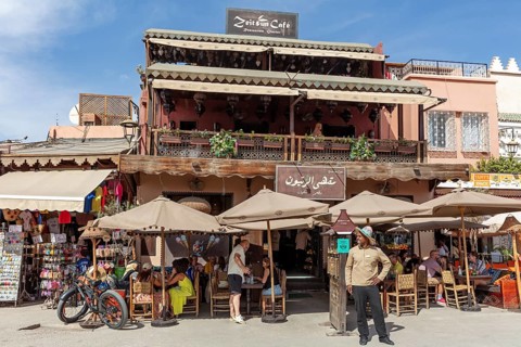 A café with a terrace where people sit and relax under umbrellas