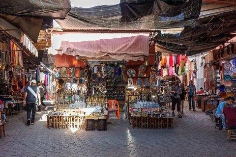 Market scene in Morocco with numerous souvenir stands and colorful cloths