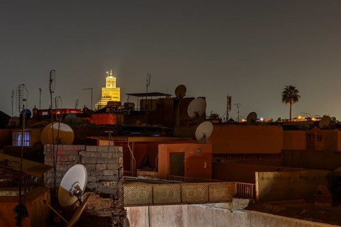 Night view in Marrakech with illuminated tower and satellite dishes