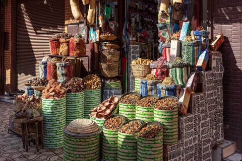 A colorful spice market in Marrakesh with bags and baskets full of fragrant spices and bright