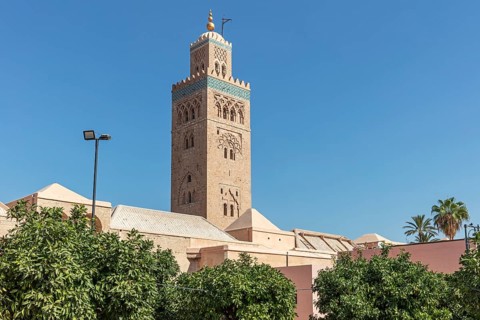 Side view of the Koutoubia Mosque with its impressive tower and palm trees