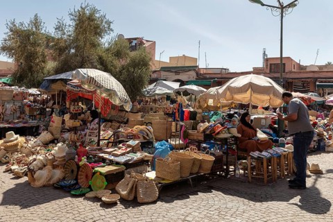 A lively marketplace with stalls full of baskets and crafts