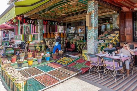 Market full of spices and decorations, people strolling or sitting relaxed
