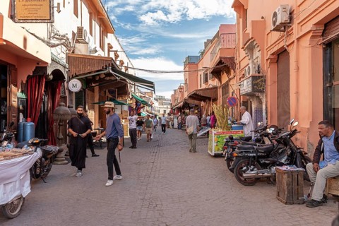 People stroll along a street with various shops