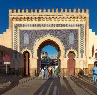 Large traditional gate with blue mosaic and people walking through