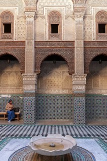 Traditional courtyard with ornate mosaics, round arches and a small fountain