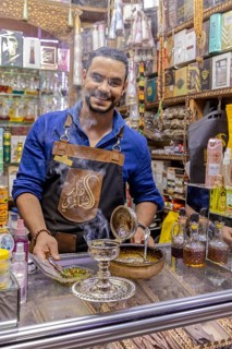 Friendly seller offers products in a busy bazaar