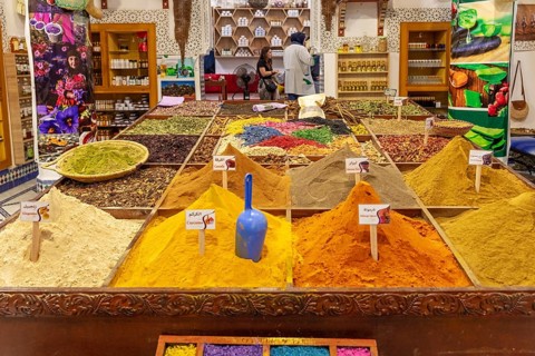 A market stand that presents a variety of colorful spices and aromatic products in various shades