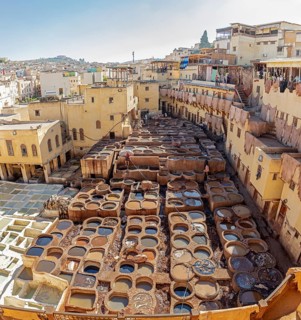 A panoramic view of a traditional old town tannery with many basins and weathered buildings in warm