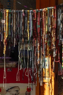 A variety of colorful chains hang on a shop door in an artisan shop