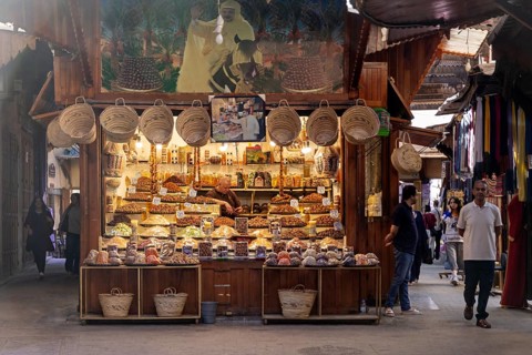 A bright market stand with hanging baskets and numerous spices in the old town