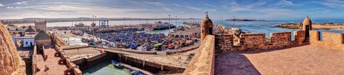 Extensive panorama of a harbor with boats and historic walls