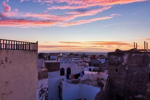 Romantic sunrise with purple clouds over the roofs of an urban environment