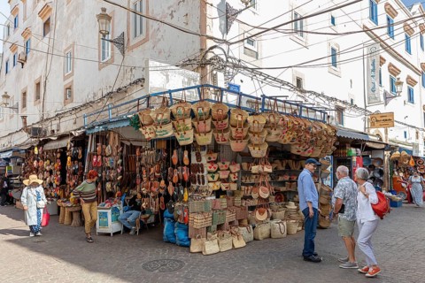 Outdoor market stalls selling traditional crafts and baskets in a sunny urban area