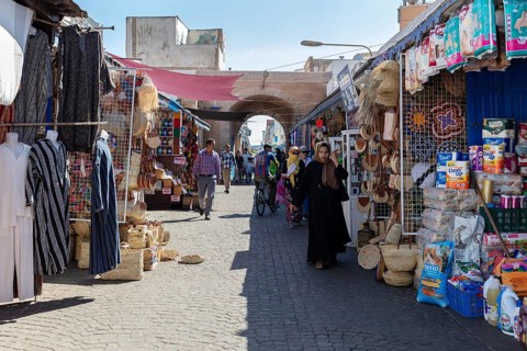 Bustling market street with numerous stalls and archways under the sun