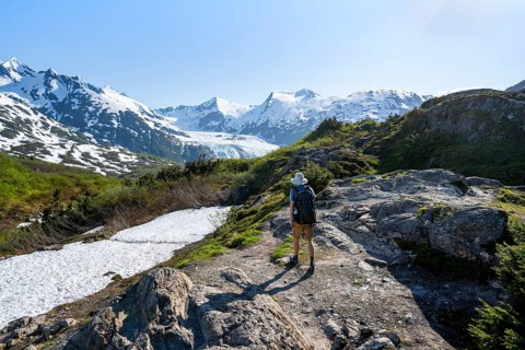 Hikers on the Portage Pass Trail, snow-covered mountains and Portage Glacier glaciers, near