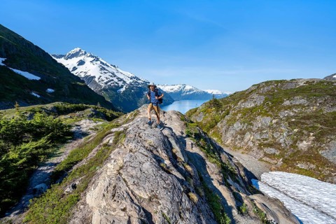 Hikers on Portage Pass, snow-covered mountains and Fjord Passage Canal, near Whittier, Alaska, USA